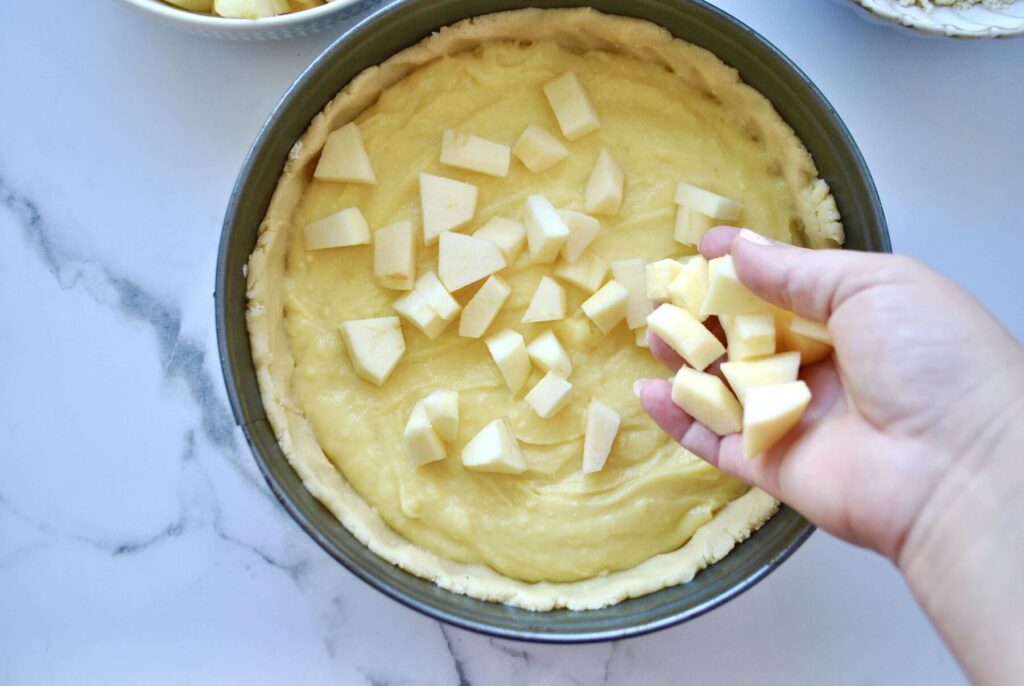 Apfelstücke zum Pudding geben für Apfelkuchen mit Pudding und Streusel