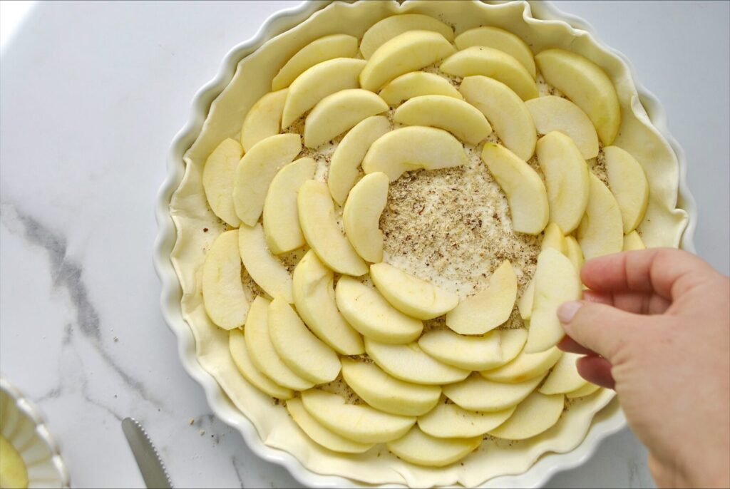 Apfelschnitze auf die Apel Tarte mit Blätterteig legen