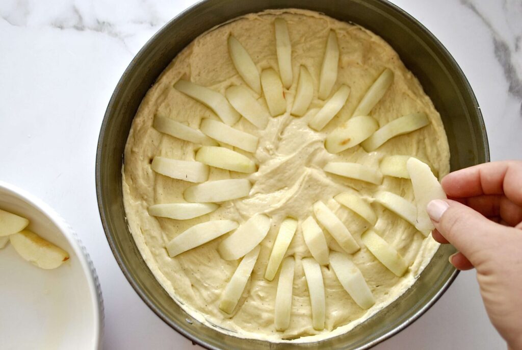 Apfelstücke in den Teig stecken für Apfelkuchen Rührteig