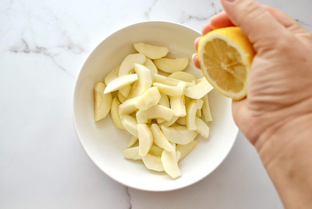 Zitronensaft über Apfelschnitze geben für Apfelkuchen Rührteig