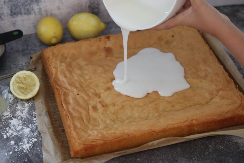 Zuckerguss auf den Kuchen geben saftiger Zitronenkuchen