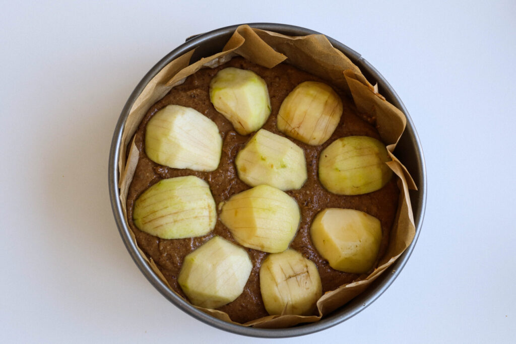 Gesunder Apfelkuchen mit Vollkornmehl- Äpfel auf dem Teig