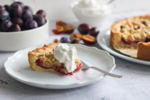 ein Stück Zwetschgenkuchen mit Sahne