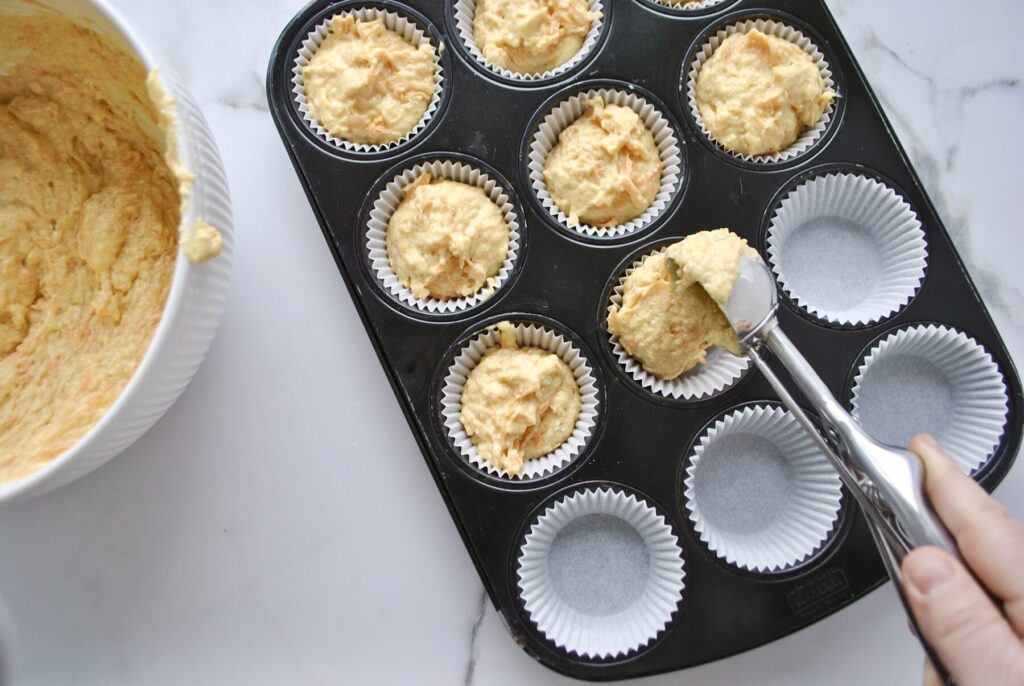 Teig in Muffinförmchen füllen für Karotten Muffins