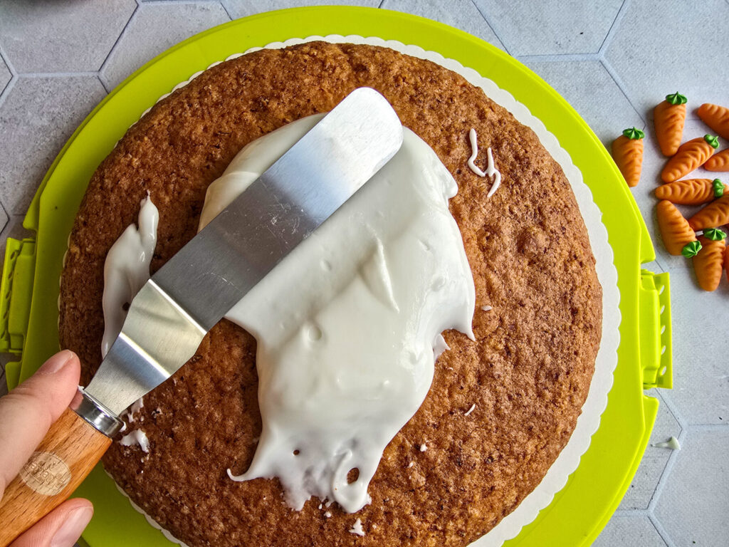 Möhrenkuchen saftig Zuckerguss auf Kuchen verteilen