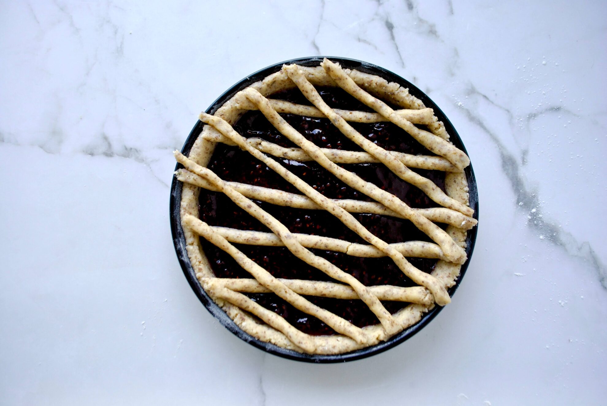 Teigrollen auf der Torte verteilen für Linzertorte