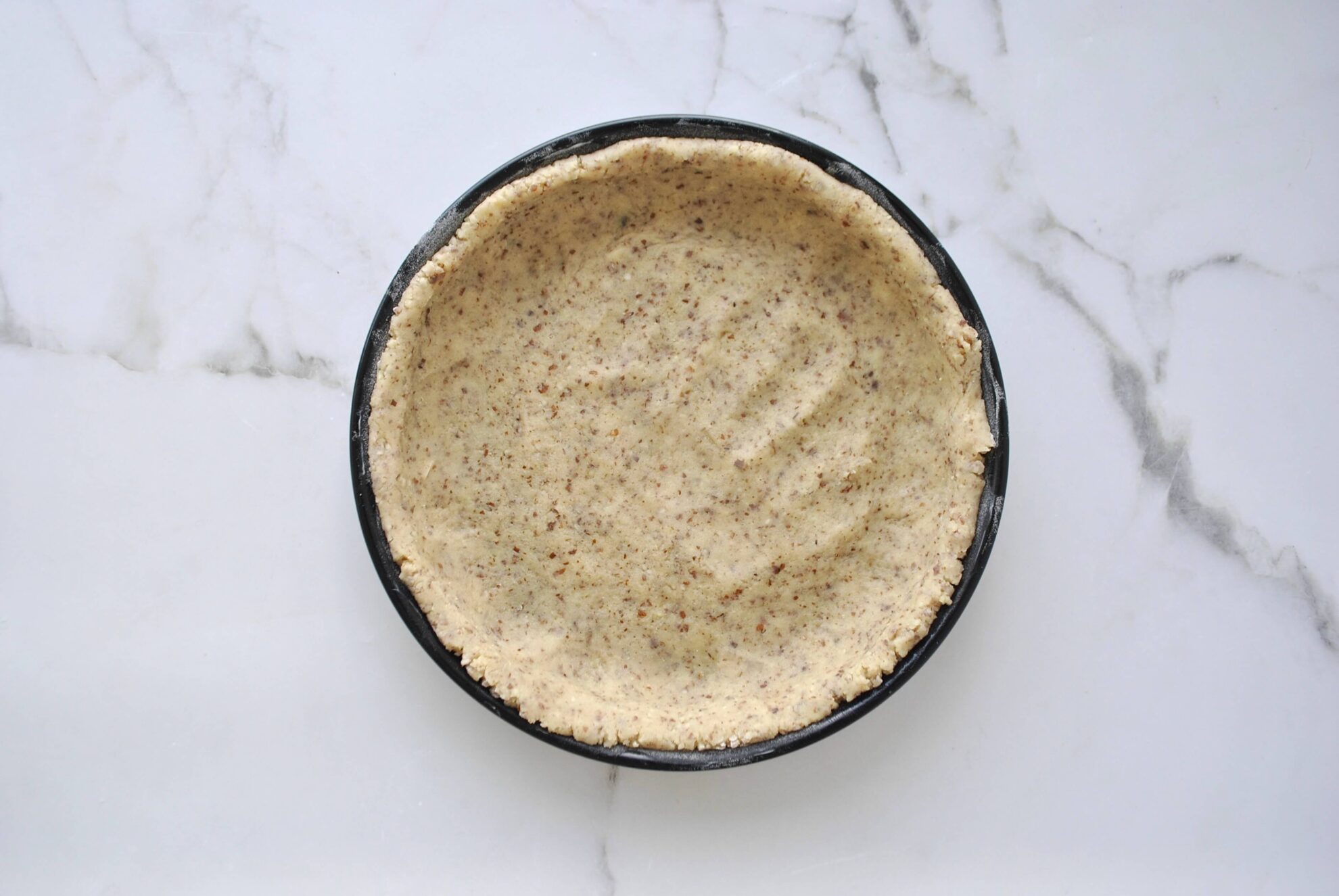 Mürbeteig in Backform drücken