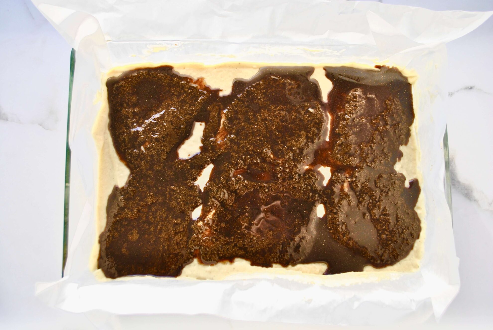 Zimtfüllung auf dem Zimtschneckenkuchen verteilen