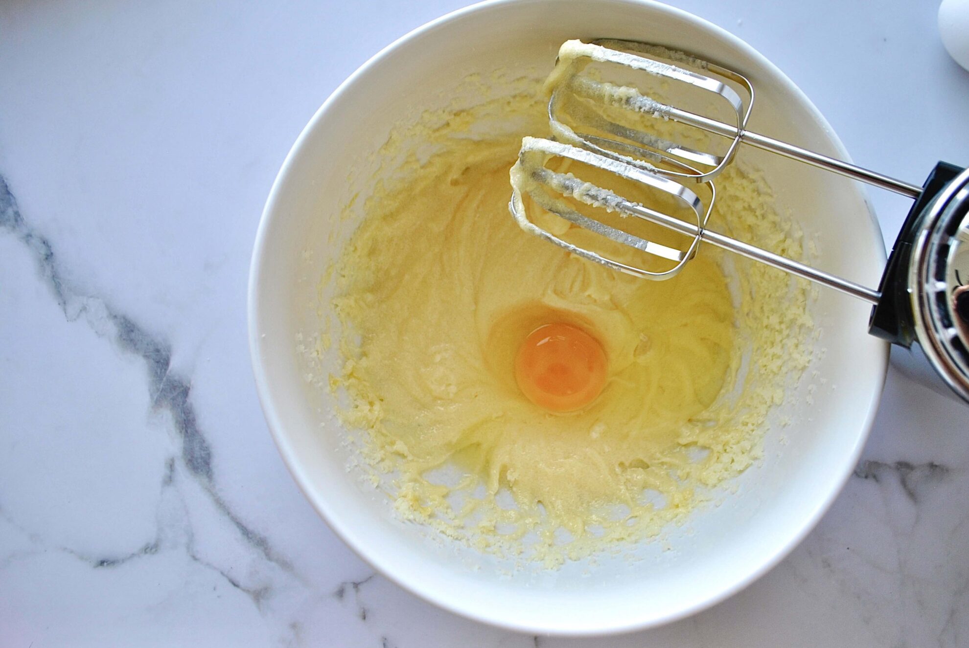 Eier zur Butter-Zuckermasse geben und einzeln aufschlagen für Zimtschneckenkuchen