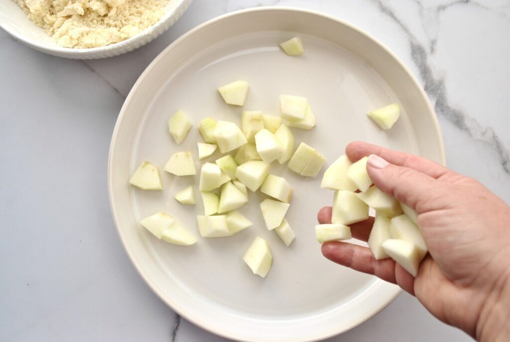 Apfelstücke in Auflaufform geben für Appel Crumble