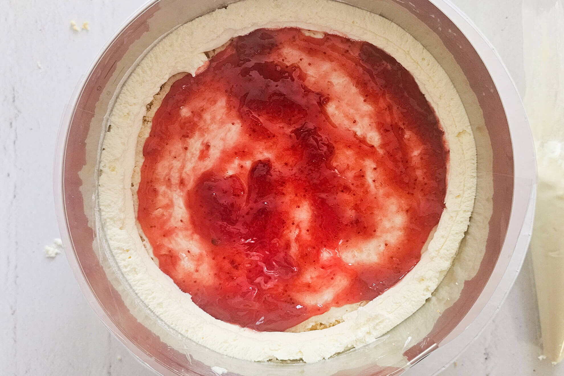 Ostertorte-mit-Mascarpone_Tortenboden-Ring-spritzen-und-Marmelade-verstreichen