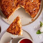 Bienenstich mit Rhabarber, knuspriger Mandelkruste und cremiger Vanillepuddingcreme auf einem Teller