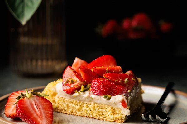Erdbeerkuchen mit Vanillepudding, weißer Schokolade und frischen Erdbeeren, angeschnitten