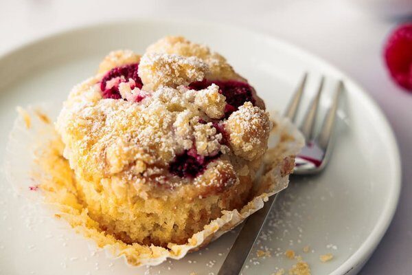 Aufgebrochener Himbeer Streusel Muffin mit sichtbarer saftiger Krume und Himbeeren