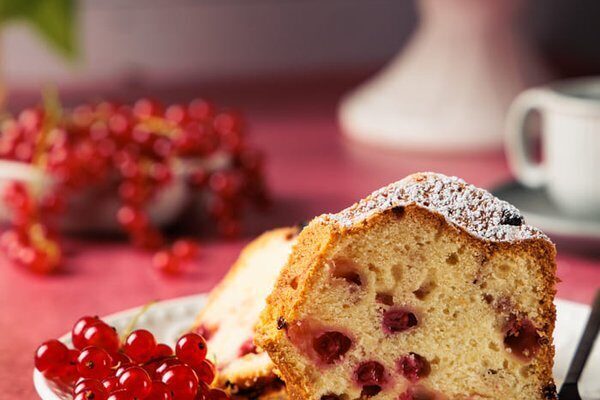 Angeschnittener Johannisbeer Gugelhupf mit sichtbaren Johannisbeeren in der saftigen Krume