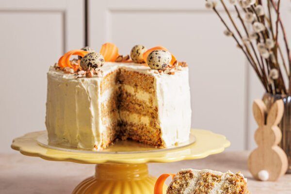 Angeschnittene Karotten Torte mit drei saftigen Nussböden und Frischkäse Creme