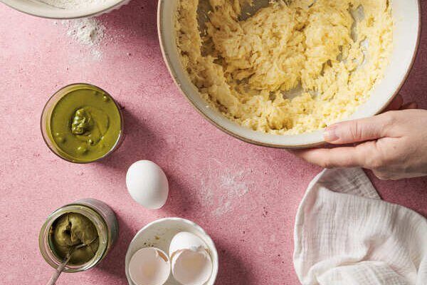 Teig mit eingerührten Eiern und Pistazienmus in Rührschüssel