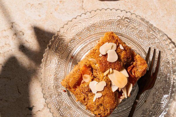 Nahaufnahme eines Stücks saftiger Aprikosenkuchen mit Mandeln