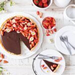 Schokoladenpudding-Tarte mit Erdbeeren von oben, knuspriger Mürbeteigboden mit cremiger Schokofüllung und frischen Erdbeeren