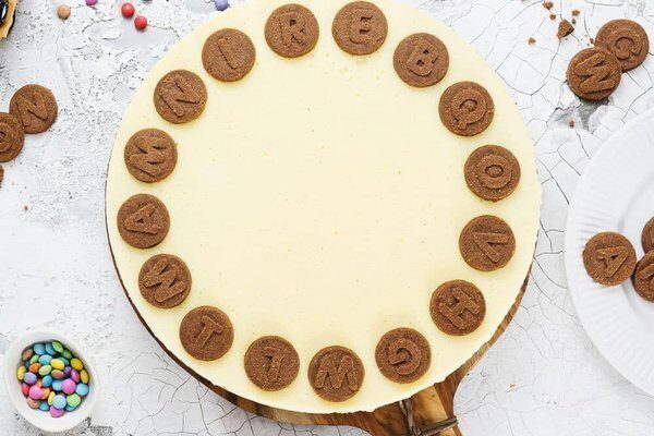 Fertig dekorierter Vanillepuddingkuchen mit Buchstabenkeksen
